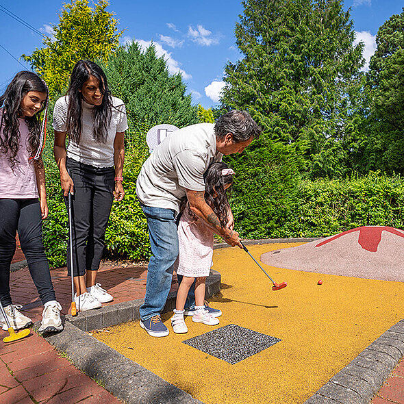 Family playing mini golf